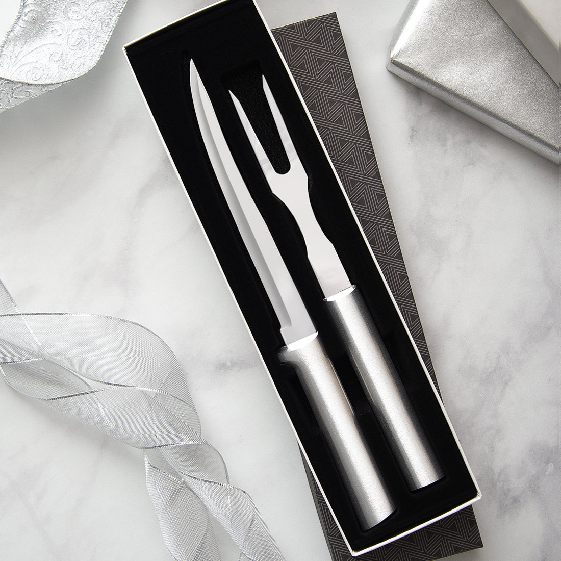 A Carving Gift Set on a marble countertop with silver ribbons