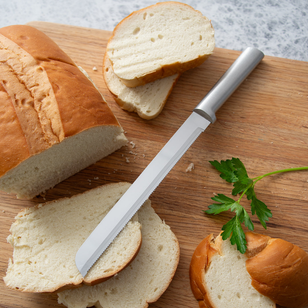 Silver Handle Bread Knife with leafy greens and sliced bread.