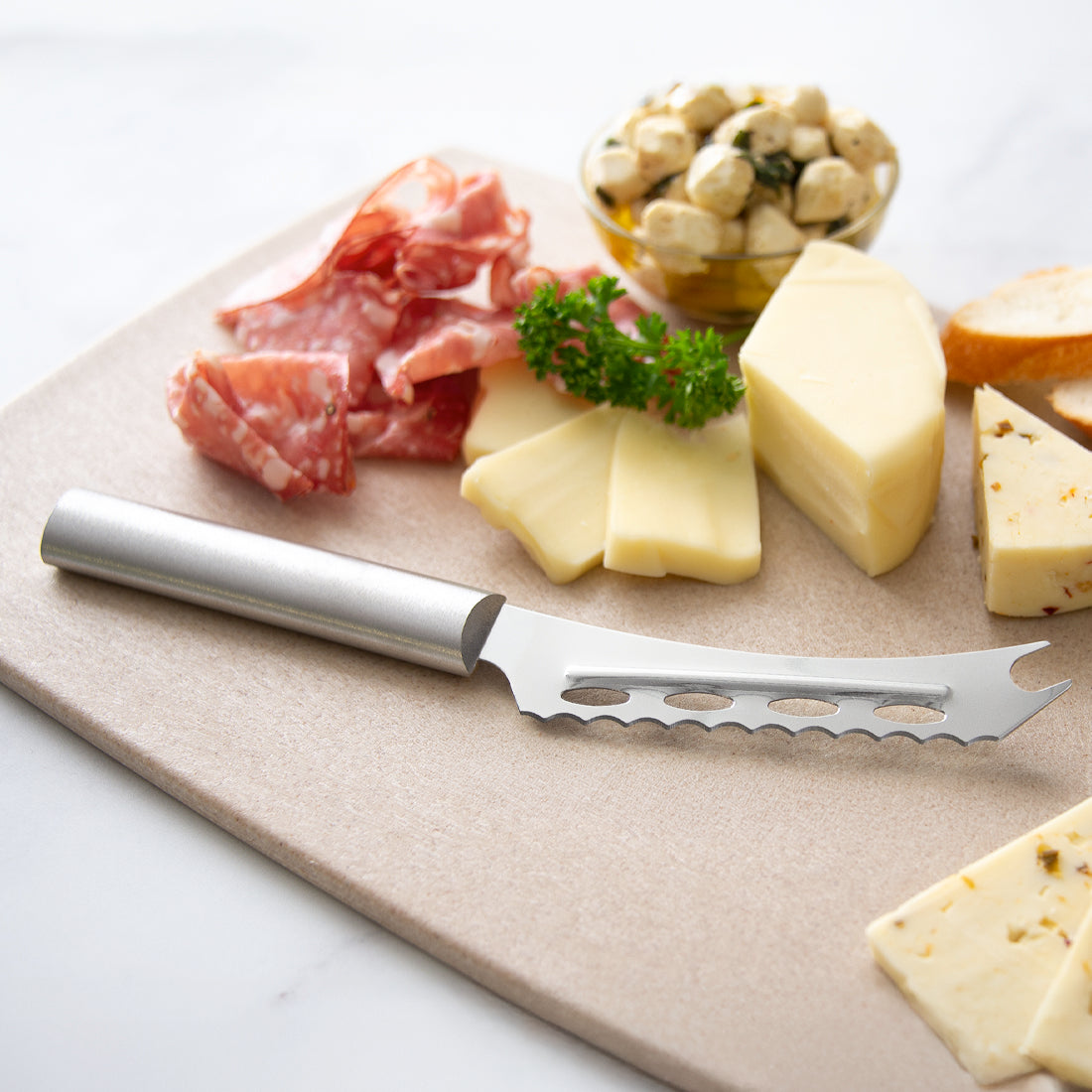 Cheese and meat platter with a cheese knife on a wooden board