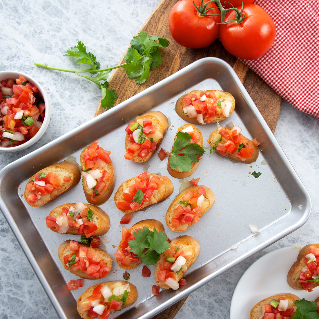 The Quarter Sheet Pan showing bruschetta bread topped with tomatoes and herbs on a wooden board.