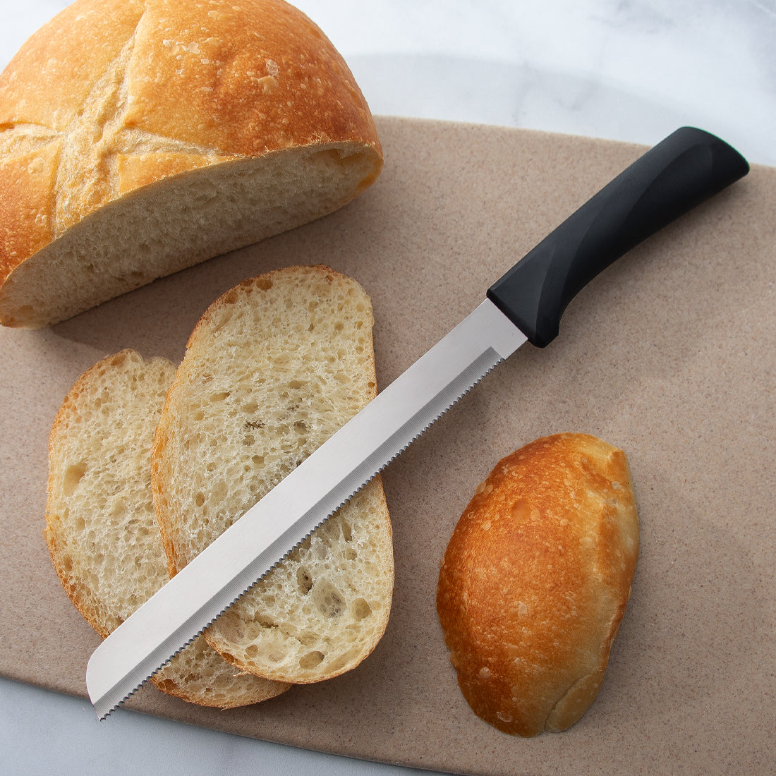 Slicing a loaf of Chibatta bread with a Rada 9 inch serrated bread knife with a black resin handle. 