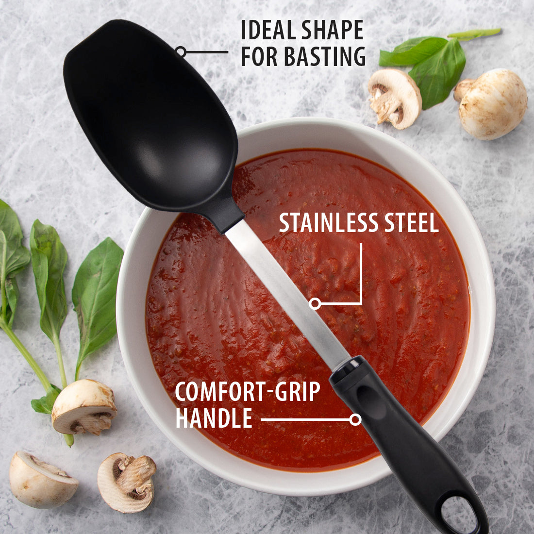Rada Cutlery Basting Spoon laying over a bowl with red sauce, and mushrooms and garnishes surrounding it.