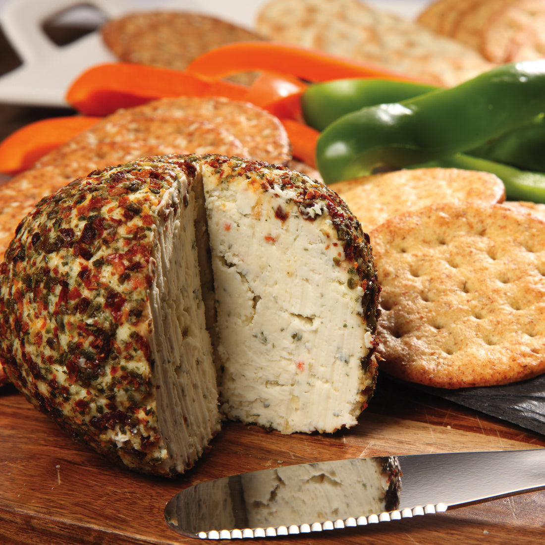 A Garden Vegetable Cheeseball next to crackers and bell pepper slices