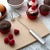 A Handi-Stir on a tan cutting board with chocolate cupcakes and raspberries