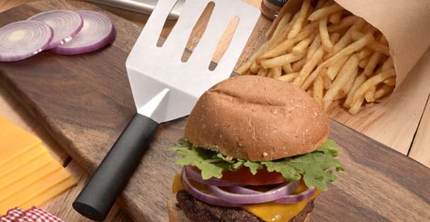 Black handled turnover with a hamburger in the for