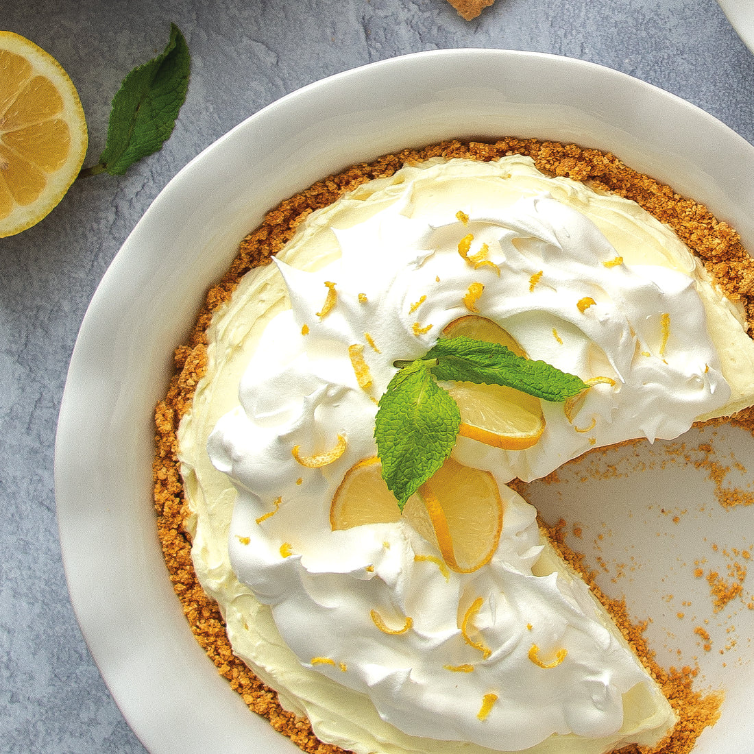 A Lemon Drop No-Bake Cheesecake in a white pan on a gray countertop.