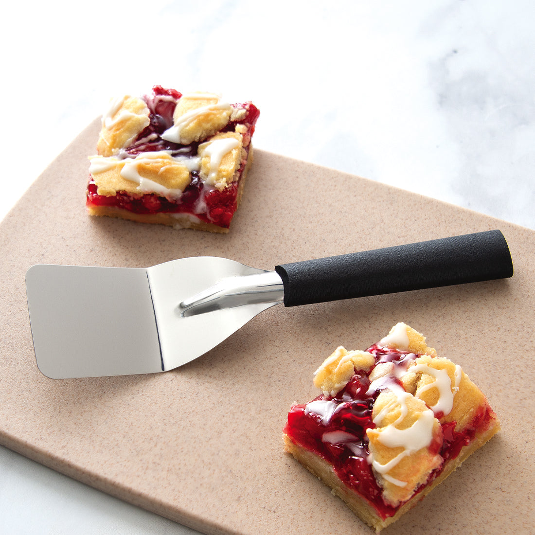 Silver handle Mini Server laying on a counter top surrounded by an egg bake.