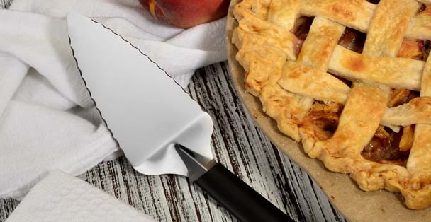 The black handled Pie Server laying by a baked lat