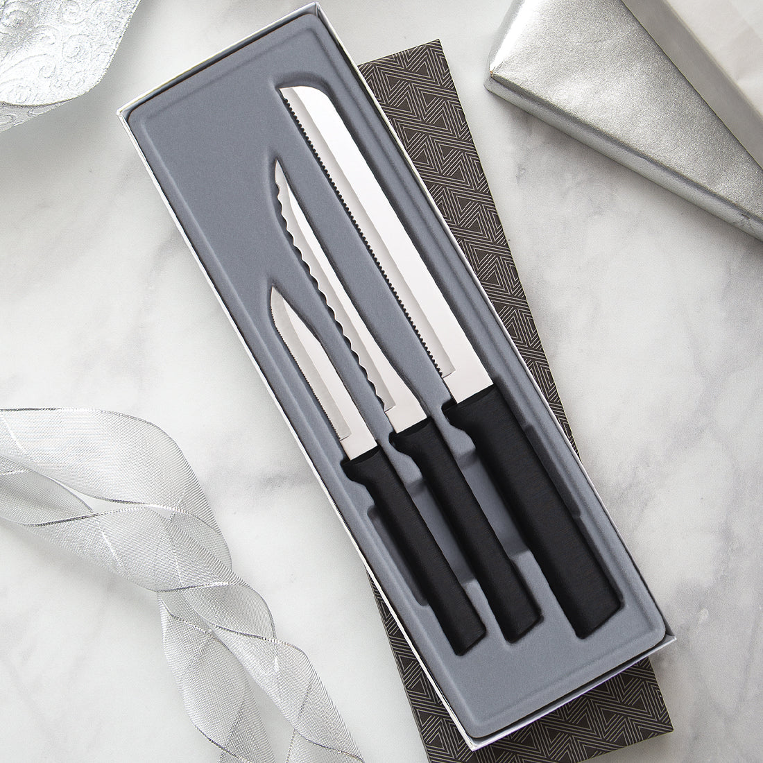3 piece silver handled Sensational Serrations Gift Set on a white table.