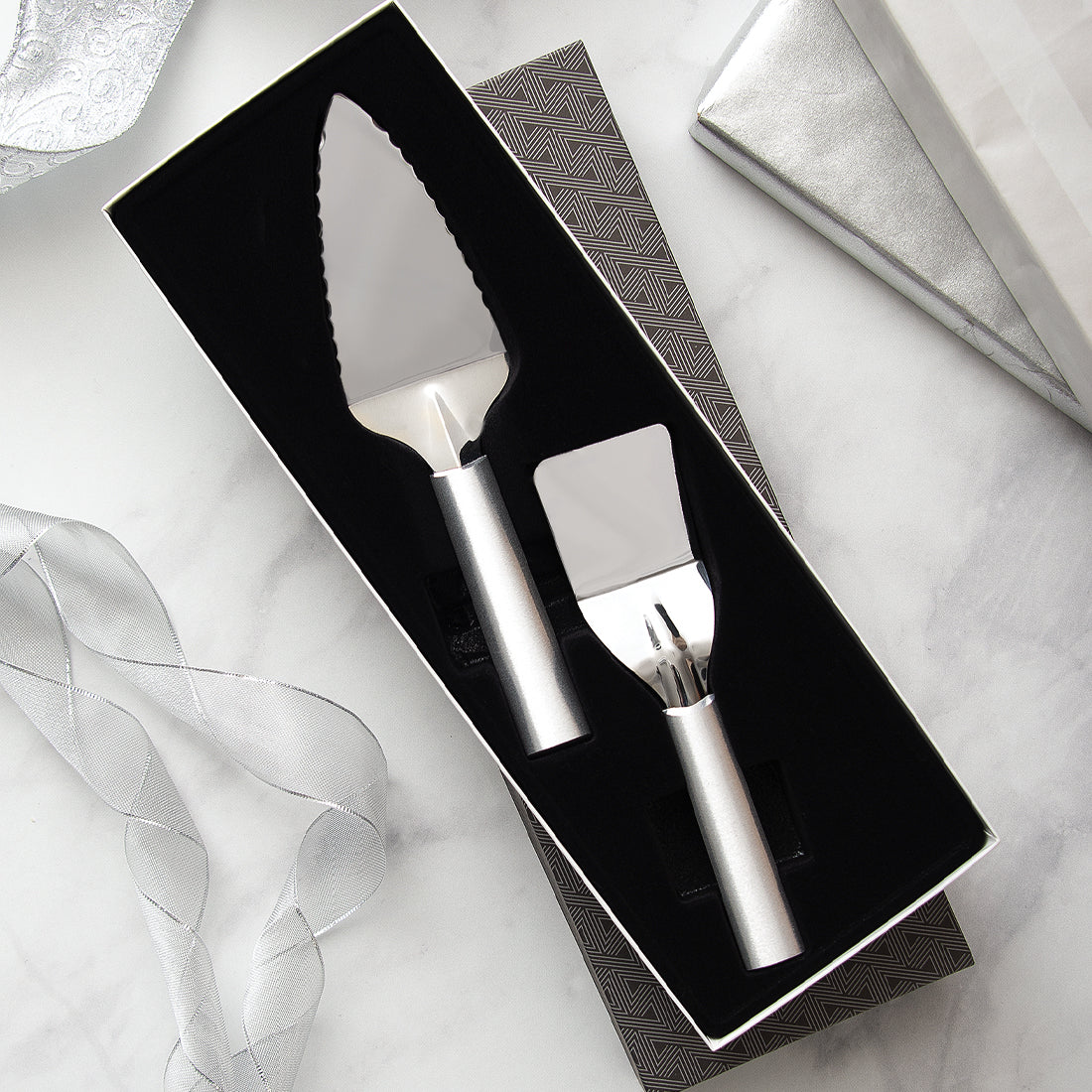 Silver handled Serving Gift Set on a marbled countertop.
