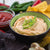 A bowl of Sriracha Ranch Dip with fresh green onion and an assortment of chips