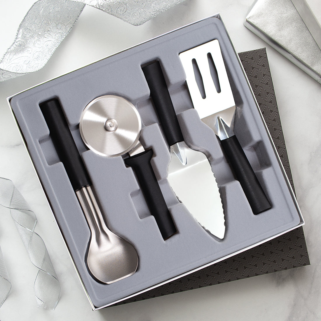 Silver handled Ultimate Utensil Gift Set on a white background with white and silver table decorations